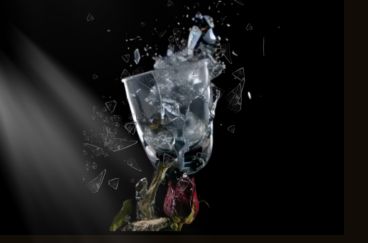 Un jarrón de cristal roto con una rosa roja marchita, simbolizando un corazón roto y el fin de una relación